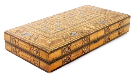 A Moorish inlaid backgammon box, profusely inlaid with finely detailed parquetry panelling and with mother of pearl, 7.5cm high, 9.5cm wide, 24.5cm deep.