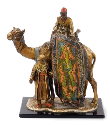 An Austrian rug seller and camel table strike lighter, manner of Franz Bergman, with patinated and cold painted finish depicting camel rider and rug seller, offering his wares, with striker, on black glass rectangular plinth, 18.5cm high.