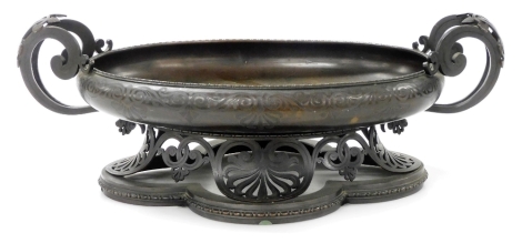 An early 20thC French bronze oval jardiniere table centre, with scrolling handles and engraved with stylised scroll decoration, raised on a scroll openwork stand with quatrefoil base, 16.5cm high, 45cm wide, 25cm deep.