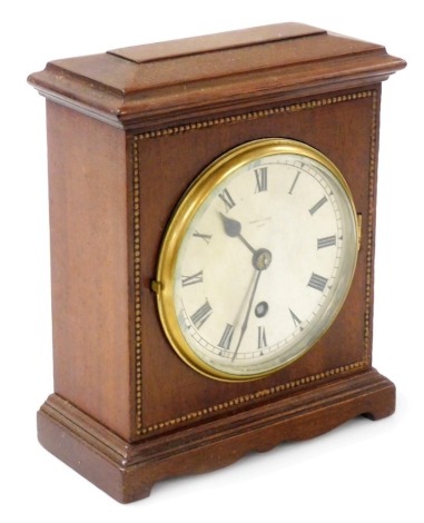 An Edwardian mahogany cased mantel clock, by Pearce & Sons of Leeds, the silver dial with Roman numerals, brass bezel and plate glass, thirty hour movement, within a plain case having beaded border to the front, 20cm high.