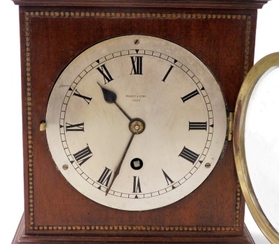 An Edwardian mahogany cased mantel clock, by Pearce & Sons of Leeds, the silver dial with Roman numerals, brass bezel and plate glass, thirty hour movement, within a plain case having beaded border to the front, 20cm high. - 2