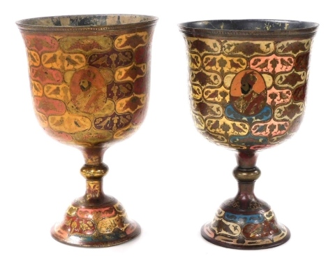 Two large similar Indian enamelled brass goblets, decorated with portrait vignettes and peacocks, within polychrome reserves of birds and fish, with knopped stems and domed circular feet, 28.5cm high.