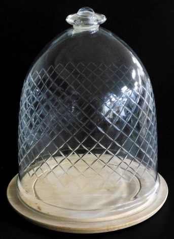 A cut glass bell shaped dome, with flat knop handle and cut with lattice decoration, 34cm high, on a turned circular birchwood base, 30cm diameter.