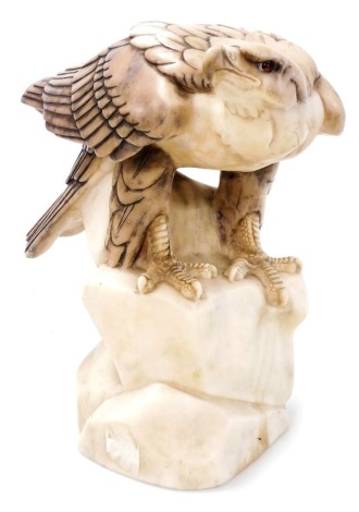 A 19thC Continental carved alabaster figure of a crouching eagle, perched on a stylised rock base, 31cm high.