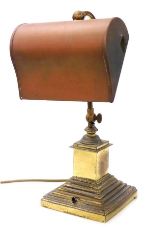 An early 20thC gilt brass desk lamp, with adjustable shaped solid shade, S shaped support, and stepped plinth base, 43cm high. Buyer Note: WARNING! This lot contains untested or unsafe electrical items. It is supplied for scrap or reconditioning only. TRA