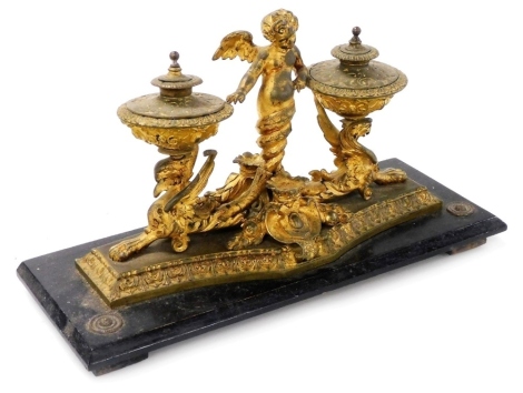 A 19thC Continental gilt metal and ebonised inkstand, decorated with a putto and griffin structure, supporting two covered inkwells, on a rectangular base, 30cm wide.