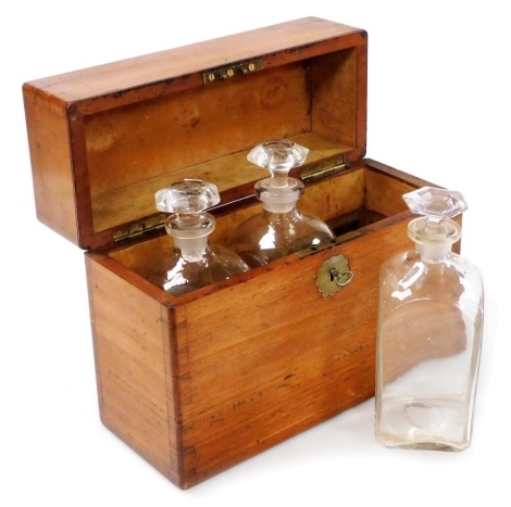 A 19thC mahogany decanter box, the hinged lid with a brass handle, enclosing three square section decanters each with a hexagonal stopper, 30cm wide. (AF)