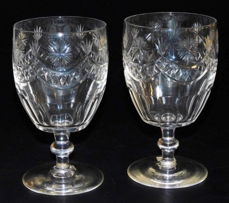 A pair of 19thC bucket shaped cut glass rummers, each decorated with stars and with swags, on a knopped stem, 16cm high.