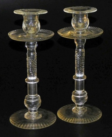 A pair of 19thC cut glass candlesticks, each with a wide drip pan and a part spirally cut and knopped column, on a domed foot, 32cm high.