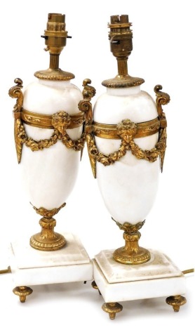 A pair of Continental white marble and gilt metal urn shaped table lamps, each on a square base, 41cm high. (AF) Buyer Note: WARNING! This lot contains untested or unsafe electrical items. It is supplied for scrap or reconditioning only. TRADE ONLY