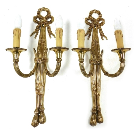 A pair of gilt metal two branch wall lights, in the 19thC manner, with pleated ribbon terminals and reeded branches and beaded sconces, 58cm high.