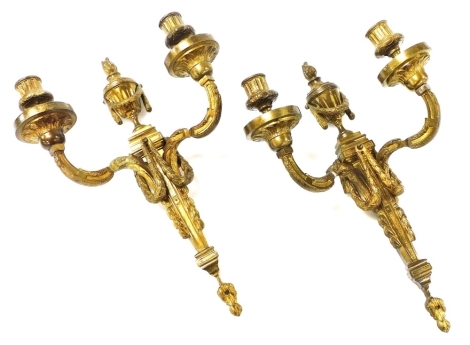 A pair of heavy brass two branch wall lights, in the French Empire manner, with flaming urn shaped finials and urn shaped sconces, on scrolling branches, 39cm high.