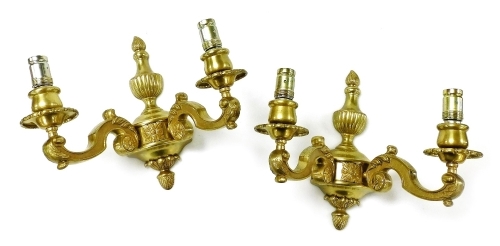 A pair of heavy brass two branch wall lights, with flaming urn shaped finials and scrolling branches, 28cm high.