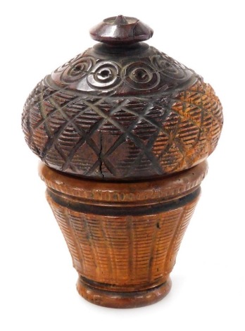 A turned and carved treen nutmeg grater, of tapering form, the screw lid with hatched and roundel decoration, with internal metal grater, 7cm high.