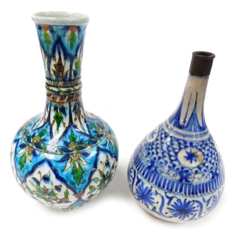 A 19thC Iznik pottery bottle vase, with slightly flared neck decorated with panels of stylised flowers in green, blue, and brown, 29cm high (AF), and another Middle Eastern bottle vase with tapered body, painted with bands of stylised flower heads and sca