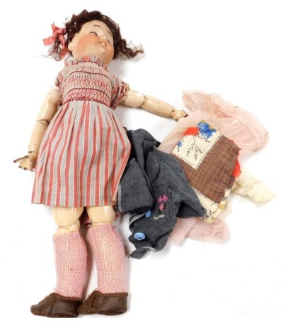 An early 20thC bisque headed doll, with blue sleep eyes, and articulated composite limbs, 43cm.