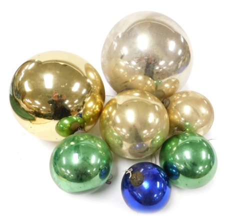 A small collection of large glass baubles or witches balls, in gold, green, and blue.