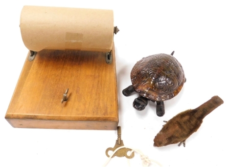 A small tinplate windup clockwork pecking bird, with key, together with a clockwork counter top tortoise bell, and a musical toilet roll dispenser.