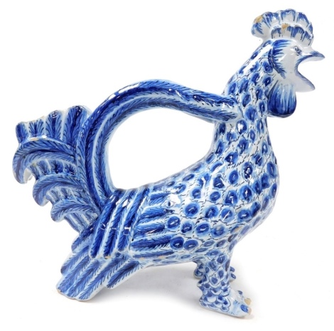 A 19thC Continental blue and white faience flagon modelled as a cockerel, in standing pose, painted W mark, 32cm wide.