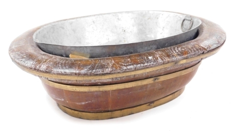 An elm and brass bound wine cooler, of oval form, with a tin liner, 51cm wide, 40cm deep.