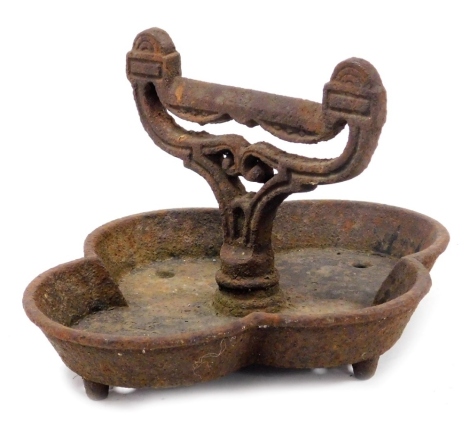 A Victorian cast iron boot scraper, raised on a quatrelobe base, 29cm wide. (AF)