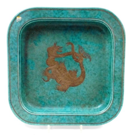 A Gustavsberg Argenta green glazed pottery dish, decorated centrally with a dragon fighting a serpent, number 1196, printed marks, 29cm wide.