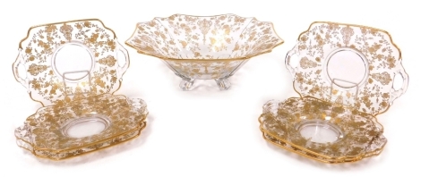 An early 20thC Continental cut glass bowl, of fluted form, engraved and gilt decorated with roses and floral motifs, 30cm wide, together with six twin handled glass dishes. (7)