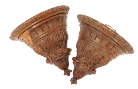 A pair of 19thC carved oak wall brackets, decorated with leaves, 26cm high.