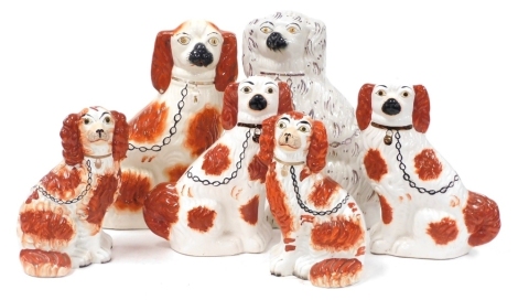 Two pairs of Staffordshire spaniels, with red and black markings, 25cm and 29cm high, further spaniel with red markings, 36cm high, and a spaniel with gilt markings, 36cm high. (6)