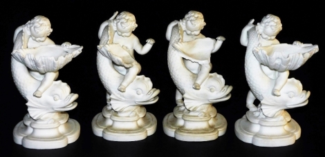 Four late 19thC Minton parian table salts, each formed as a putto and dolphin, with a shell shaped bowl, raised on a quatrelobe base, bears registration lozenge and impressed marks, 17cm high. (AF)