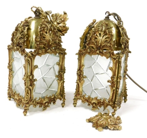 A pair of heavy brass and glass hall lanterns, embossed with flowers and foliate scrolls, the panels of cracked ice form, 28cm high.