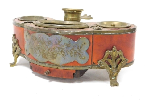 A late 19thC French brass and tortoiseshell desk stand, of kidney form, with a chamberstick handle, with inkwell stander and further apertures, brass plaque to the front engraved with flowers, over a single frieze drawer, raised on four scroll feet, 21cm 