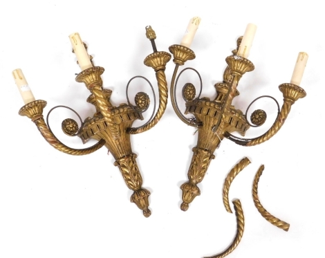 A pair of early 20thC giltwood three branch wall lights, with fluted and foliate carving, 49cm high. (AF).