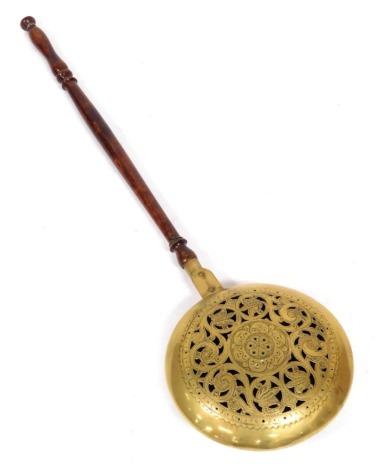 An 18thC copper and brass bed warmer, with a turned wooden handle, pierced and stipple engraved with flowers, 109cm high.