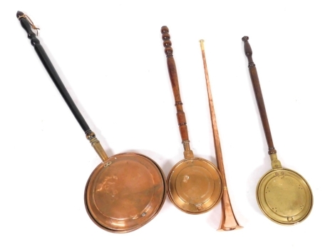 A 19thC copper and brass post horn, copper warming pan, further copper warming pan, and a brass warming pan. (4)