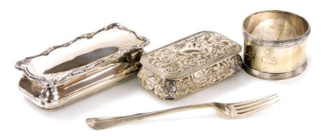 A group of small silver, comprising two rectangular dressing table boxes, one of plain form with a waved border to lid, Birmingham 1902, the other embossed profusely with flowers, leaves and scrolls, Birmingham 1897, together with a napkin ring and a cake