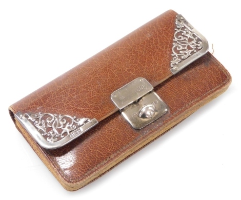 A late Victorian brown leather and silver mounted purse, the silver clasp enclosing compartments for coins and cards, marks for London and Birmingham 1900, 11cm wide.