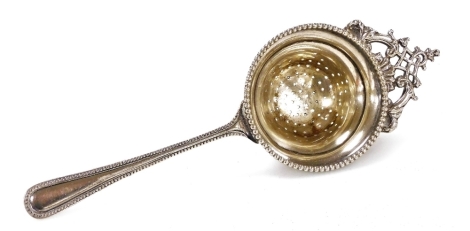 A George V silver tea strainer, with a raised beaded border, Sheffield 1919, 1.94oz.