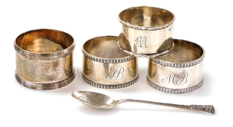 A group of small silver, comprising four napkin rings of differing designs and dates, together with a souvenir spoon for Clovelly, Birmingham 1971, 4.57oz.