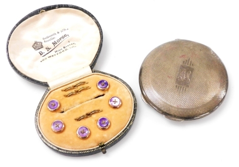 A set of six purple mother of pearl shirt buttons, in rose metal circular mounts, with fastenings, by B S Morse, Watford, cased, together with a George V silver compact, with engine turned decoration, stylised rectangular reserve, monogram engraved, Birmi