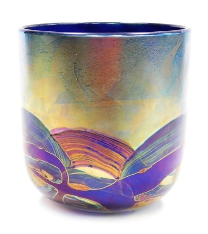 A Michael Harris Isle of Wight glass 'Nightscape' vase, of cylindrical form, decorated with iridescent trails against a blue ground, with paper label and signed to underside, 21cm high, 20cm diameter.