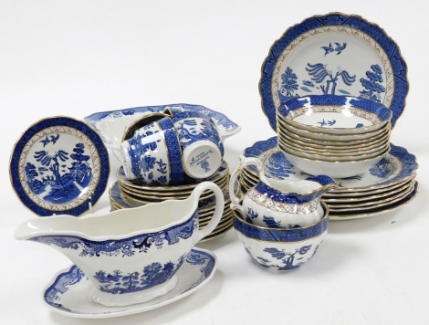 A group of Booths Real Old Willow pattern tea and dinner wares, to include breakfast bowls, teacups and saucers, gravy boat and saucer, square dish, milk jug, etc.