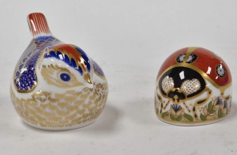 Two Royal Crown Derby porcelain paperweights, modelled as a goldcrest, with gold stopper, and ladybird seven spot, red printed marks and gold stopper.