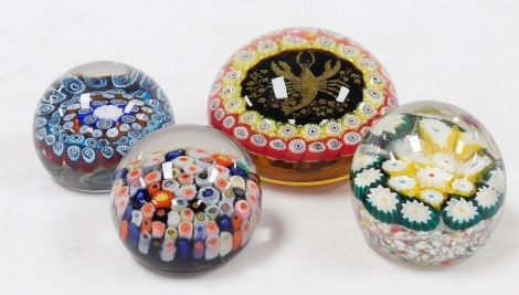 A group of glass paperweights, to include a Murano glass paperweight, inset centrally with a study of a lobster, stamp to underside handmade Murano 1960, 8.5cm diameter, together with three further millefiori paperweights.