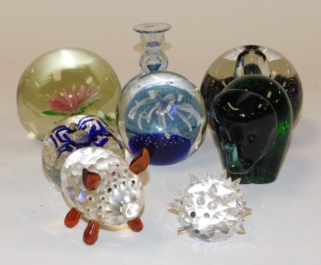 A group of glass paperweights, one inset with a pink and white flower, 10cm diameter, together with a Wedgwood paperweight modelled as an elephant in green and blue, 9.5cm high, a Swarovski Crystal hedgehog, a faceted glass model of a pig, etc. (a quantit