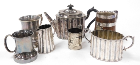 An Elkington & Co silver plated three piece tea service, comprising teapot, milk jug and two handled sugar bowl, together with further electroplated tankards, and a silver plated and oak coopered pint mug, bearing shield crest, 15cm high.