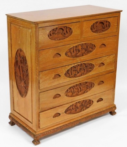 A 20thC oak chest in the Oriental style, the top with a rounded edge above two short and four long drawers, carved panels to each side, each handle carved with oriental landscape scenes, four carved feet, 106cm high, 97cm wide, 45cm deep.