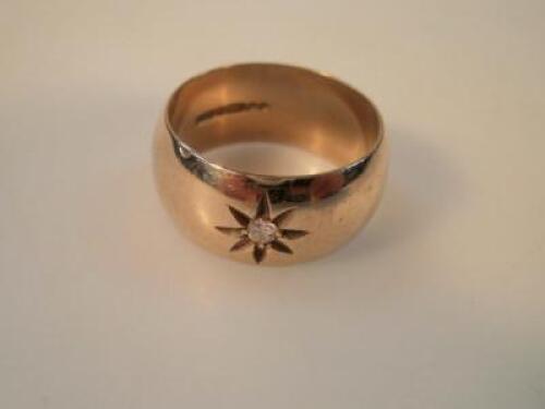 A large 9ct gold wedding band with inset small single diamond