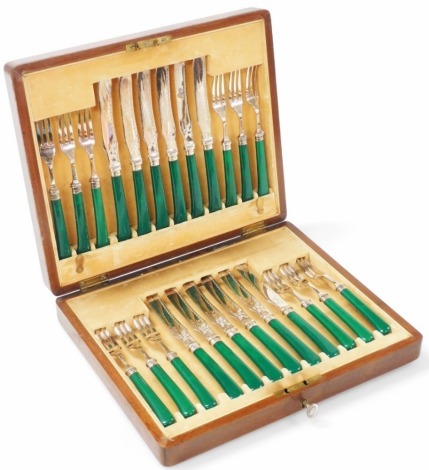 A set of twelve Edward VII dessert knives and forks, with electroplated blades and prongs, silver collar and a green simulated Jade handles, Sheffield 1908, in a mahogany fitted case.