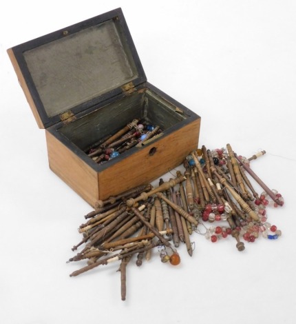 A Victorian mahogany and marquetry inlaid box, the hinged lid enclosing a quantity of lace bobbins with beads, the caddy 17cm wide.